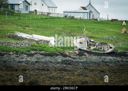 Flatey Island, Iceland - July 2, 2023: Old abandoned shipwreck fishing boat on a beach Stock Photo