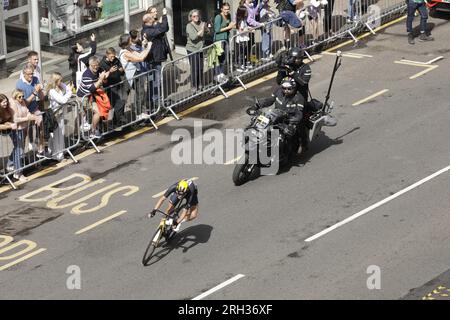 Glasgow, Scotland, UK. 13th August 2023. Kim Cadzow of New Zealand being filmed by an official race videographer on a motorbike, curving out of Byres Road in the West End of Glasgow during the  UCI Cycling World Championships finished with the Women Elite Road Race, which started at Loch Lomond and ended with six laps of Glasgow's city streets. Credit: Elizabeth Leyden/Alamy Live News Stock Photo