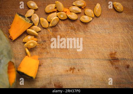 background close-up top view with pumpkin seeds on wooden cutting board with copy space, halloween and thanksgiving concept Stock Photo