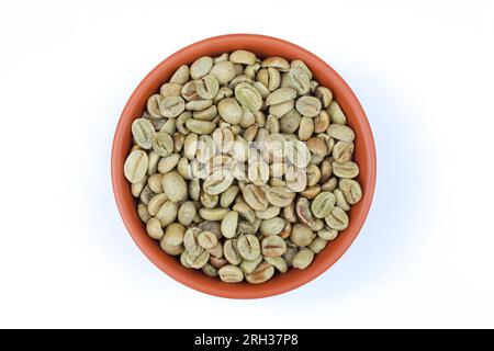 Green coffee beans in a bowl on white background close-up view Stock Photo