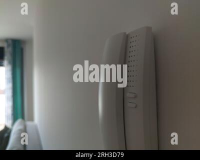 Intercom attached on the wall of living room. Window light at bottom. Blurred foreground Stock Photo