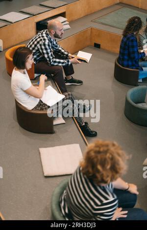A shot of young employees listening to a presentation at the amphitheater Stock Photo