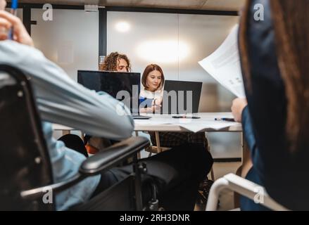 Group of business people working at the office. Experienced male programmer fixing his female colleague code error Stock Photo