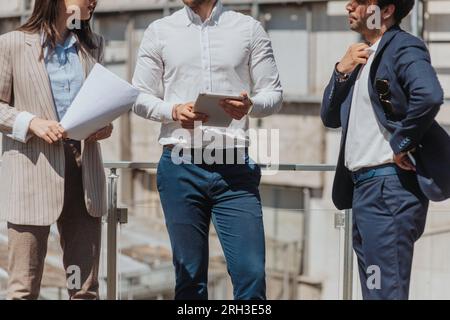 Architects discussing work while standing on a construction site in the city. Cropped photo Stock Photo