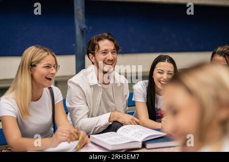 Intelligent students studying in a good atmosphere, having fun and laughing while preparing an exam together Stock Photo