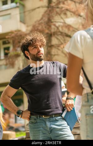 Young and handsome male student talking with his classmate while taking a break from classes Stock Photo