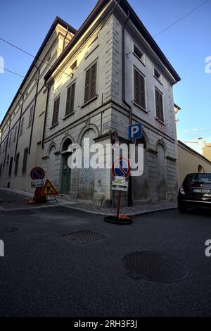 Corner  of a building at the crossroad of two street in an italian town at sunset Stock Photo