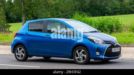 Milton Keynes,UK - Aug 13th 2023: 2014 blue hybrid electric Toyota Yaris  car driving on an English country road. Stock Photo