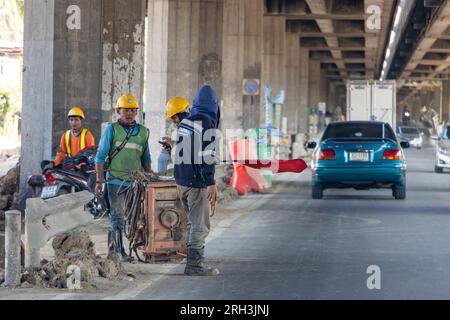 BANGKOK, THAILAND, JAN 28 2023, A man with a flag regulates traffic at the entrance to the construction site Stock Photo