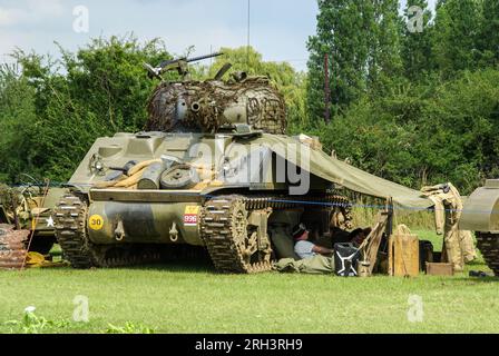 Re-enactment of a Second World War Sherman tank crew encampment. Tank crew under canvas beside World War Two armour in wartime scenario Stock Photo
