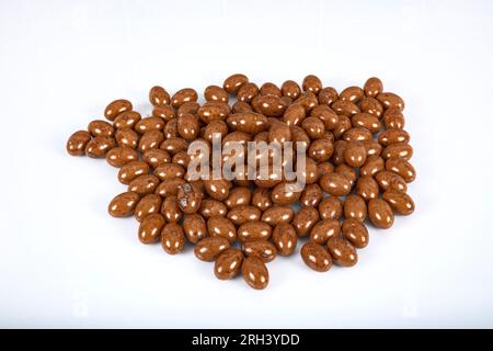 Colored chocolate dreje. Dark chocolate filled hazelnuts. Colorful chocolate candies and Pebblestone chocolate dragees. Decoupage on a white backgroun Stock Photo
