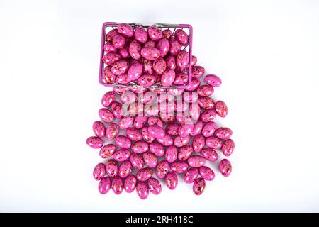 Colored chocolate dreje. Dark chocolate filled hazelnuts. Colorful chocolate candies and Pebblestone chocolate dragees. Decoupage on a white backgroun Stock Photo