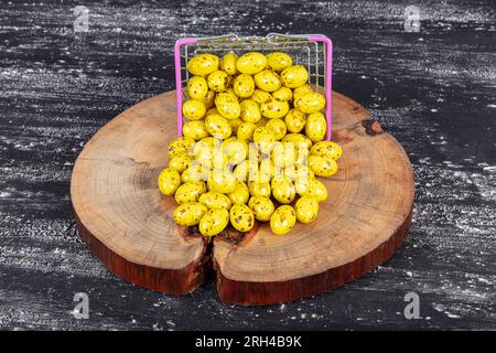 Heap of sugared almonds and hazelnuts dragees in chocolate isolated on dark background. Handmade colorful chocolate candies filled with nuts. Chocolat Stock Photo