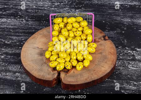 Heap of sugared almonds and hazelnuts dragees in chocolate isolated on dark background. Handmade colorful chocolate candies filled with nuts. Chocolat Stock Photo