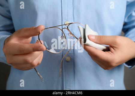 Woman cleaning glasses with microfiber cloth, closeup Stock Photo