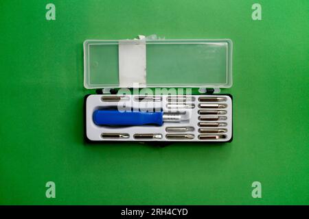 Screwdriver set with nozzles in a plastic box isolated on green background Stock Photo