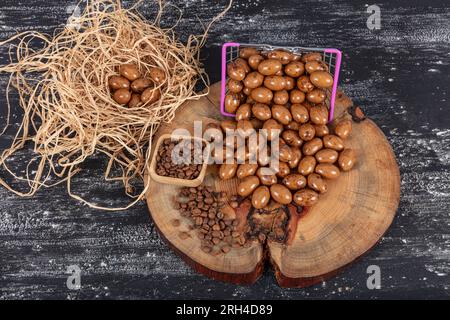 Heap of sugared almonds and hazelnuts dragees in chocolate isolated on dark background. Handmade colorful chocolate candies filled with nuts. Chocolat Stock Photo