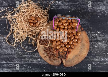 Heap of sugared almonds and hazelnuts dragees in chocolate isolated on dark background. Handmade colorful chocolate candies filled with nuts. Chocolat Stock Photo