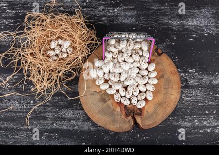 Heap of sugared almonds and hazelnuts dragees in chocolate isolated on dark background. Handmade colorful chocolate candies filled with nuts. Chocolat Stock Photo