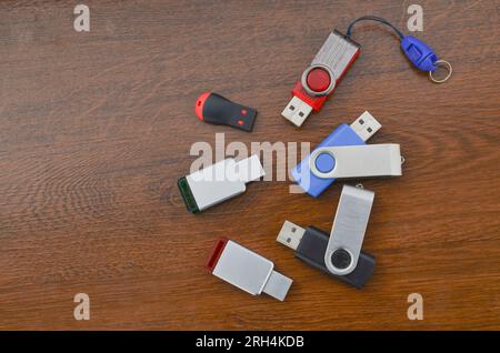 Closeup of several USB sticks on the wooden table. Several different USB sticks. Flash drives representing mobile storage and advanced technology. Stock Photo