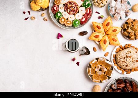 Middle Eastern Sweets, Turkish Delights and Coffee on white background, copy space. Arab dessert assortment, rahat lokum, halva, sherber, pismaniye wi Stock Photo