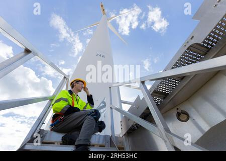 Engineer professional techician male working using laptop setup wind turbines system control operate service at location site Stock Photo