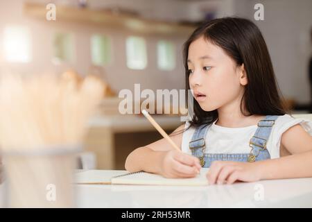 Cute child girl happy learning education doing home work at home holiday Stock Photo