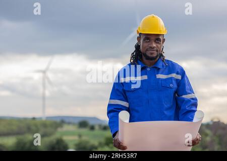 Wind turbine technician checking service. Black African Engineer professional working maintenance clean power generator system Stock Photo