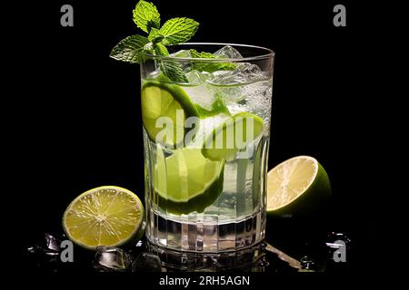 A detailed mojito glass filled with refreshing ingredients, contrasted against a pure black background. Stock Photo