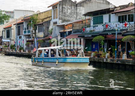 Malacca River Cruise boat sailing down the river on a sunny day Stock Photo