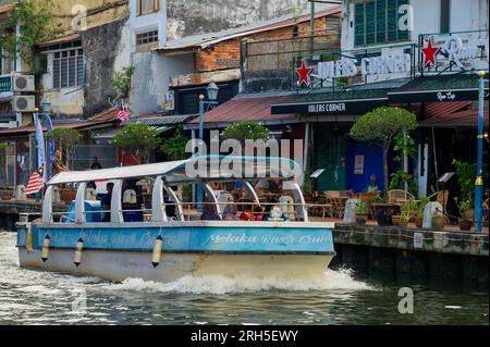 Malacca River Cruise boat sailing down the river on a sunny day Stock Photo