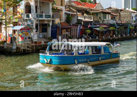 Malacca River Cruise boat sailing down the river on a sunny day Stock Photo