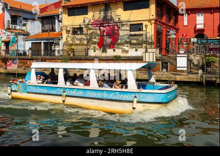 Malacca River Cruise boat sailing down the river on a sunny day Stock Photo