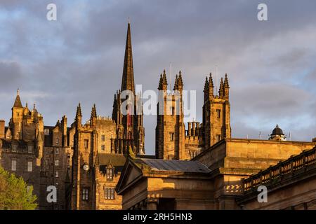 Old Town of Edinburgh city at sunset with towers of New College on The Mound and spire of The Hub building, former Tolbooth Church in Scotland, UK. Stock Photo