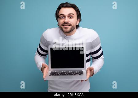 smart european young guy with chic black hair shows promotional offer on blank screen Stock Photo