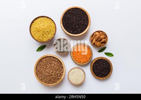 Various superfoods in smal bowl on colored background. Superfood as rice, chia, quinoa, lentils, nuts, sesame seeds, almonds. top view copy space. Stock Photo