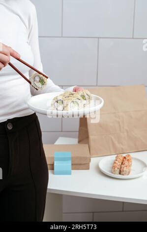 a girl holds a plate of Japanese sushi in her hands Stock Photo