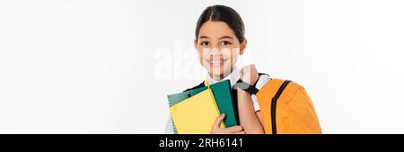 happy schoolgirl standing with notebooks in and backpack in hands, new school year concept, banner Stock Photo