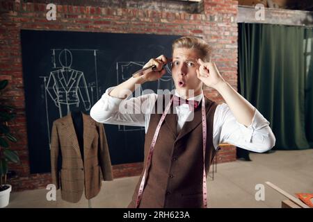 Young man, fashion designer with emotional face, generating new clothing collection ideas. Creative thinking Stock Photo