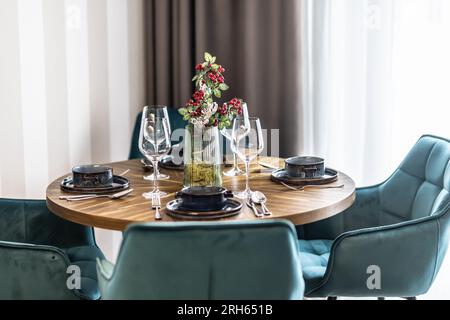Dining room with wooden table and blue chairs floor in modern apartment. Modern setting in the dining area of the apartment. Stock Photo