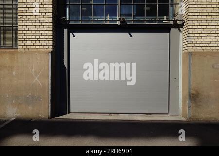 Large closed delivery rolling gate. Urban building, exterior view, no people. Stock Photo