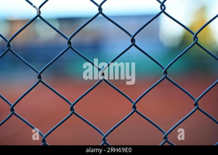 Wire fence mesh pattern. Close up shot, shallow depth of field, dim evening sunset light, no people. Stock Photo