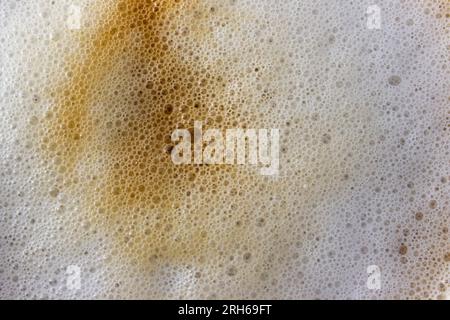 Top view of coffee foam texture. Cappuccino background with whipped foam and small bubbles Stock Photo