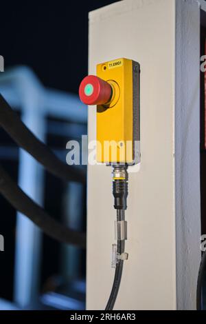 big red button in a factory. yellow base, red button and green light on the red button. Stock Photo