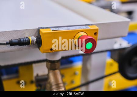 big red button in a factory. yellow base, red button and green light on the red button. Stock Photo