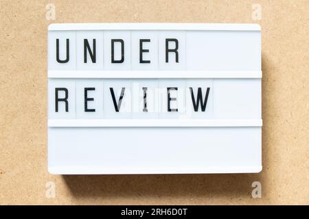 Lightbox with word under review on wood background Stock Photo