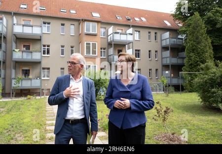 14 August 2023, Saxony-Anhalt, Halle (Saale): Klara Geywitz (SPD), Federal Minister of Construction, visits a landscaped courtyard of the Bauverein Halle cooperative alongside Guido Schwarzendahl, board member of the Bauverein, in the Luther Quarter in Halle/Saale on her summer trip. The Federal Ministry of Construction had supported the transformation of the listed cooperative quarter in the Saale city until May 2022 by means of an energetic quarter concept and a redevelopment management. The core of the project is to increase the quality of living while maintaining affordable rents by redesi Stock Photo