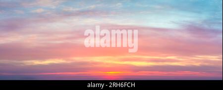 Real amazing panoramic sunrise sundown sunset sky with gentle colorful clouds. real sky and clouds. Without any birds. Stock Photo