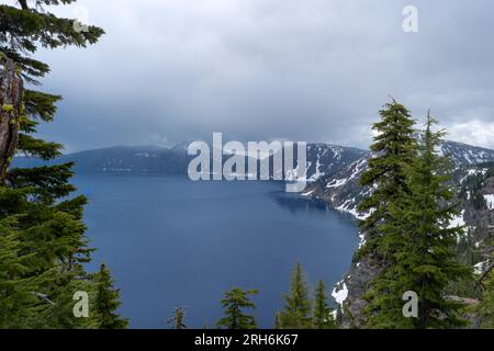 Looking over the rim into the Caldera of a volcano at Crater Lake National Park in Oregon on a stormy day. Stock Photo