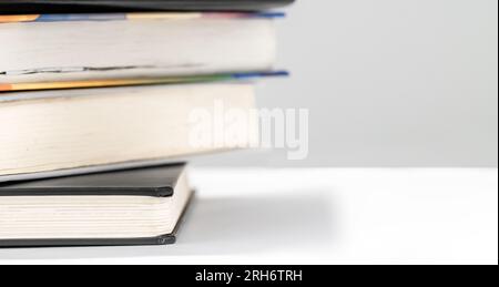 Stacks of educational books on a white table. Home preparing for exams. Copy space Stock Photo